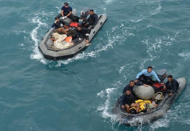 Buzos revisan restos de la cola de avión de AirAsia en búsqueda de cajas negras Buzos revisan restos de la cola de avión de AirAsia en búsqueda de cajas negras