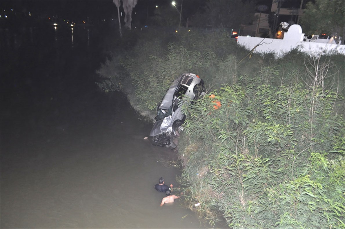 ZONA CENTRO. Elementos de cuerpos de emergencias realizan maniobras para extraer una camioneta que cayó al canal, muriendo sus ocupantes.