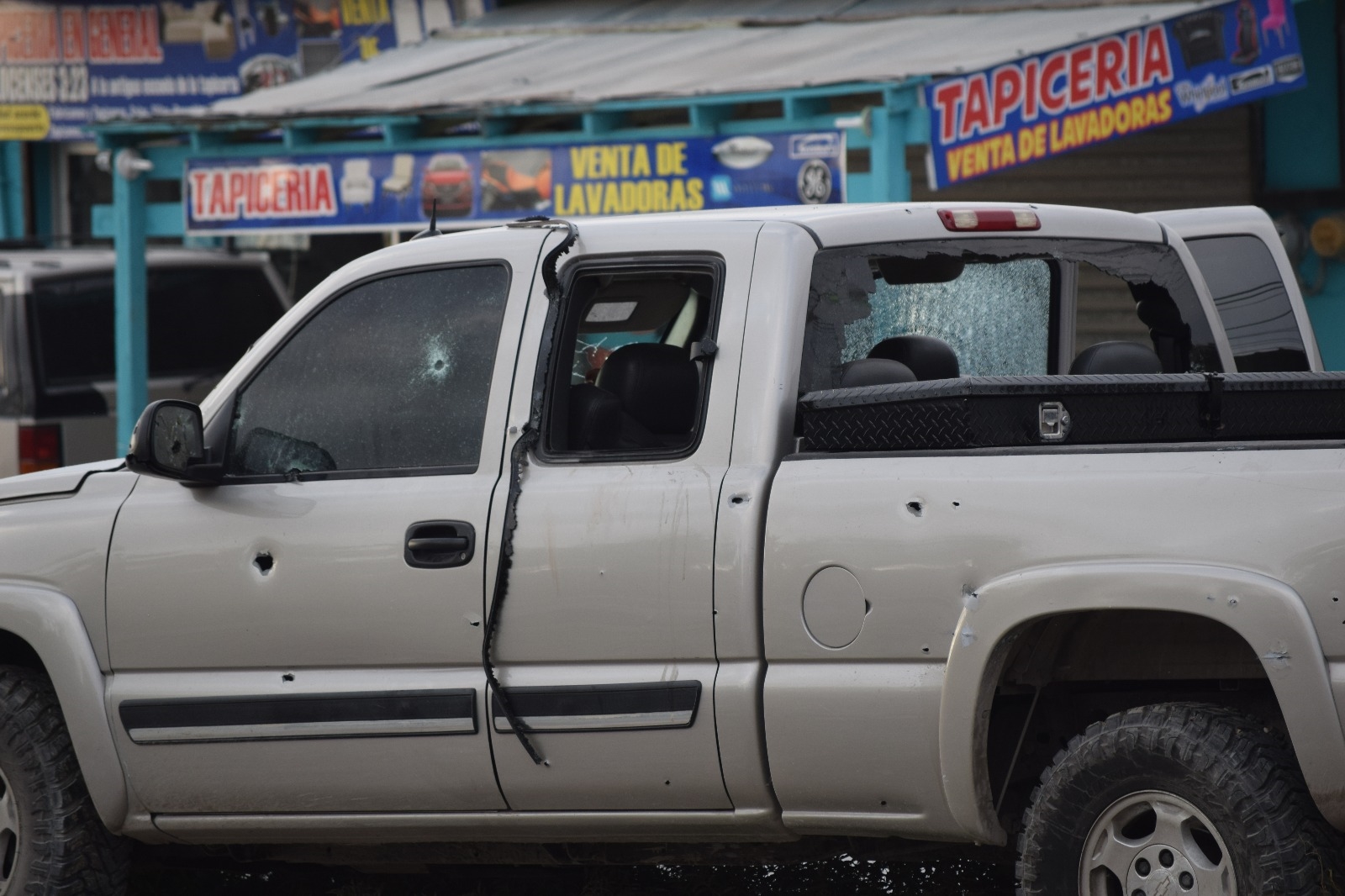 El sujeto muerto dentro de la camioneta baleada, una Chevrolet Silverado