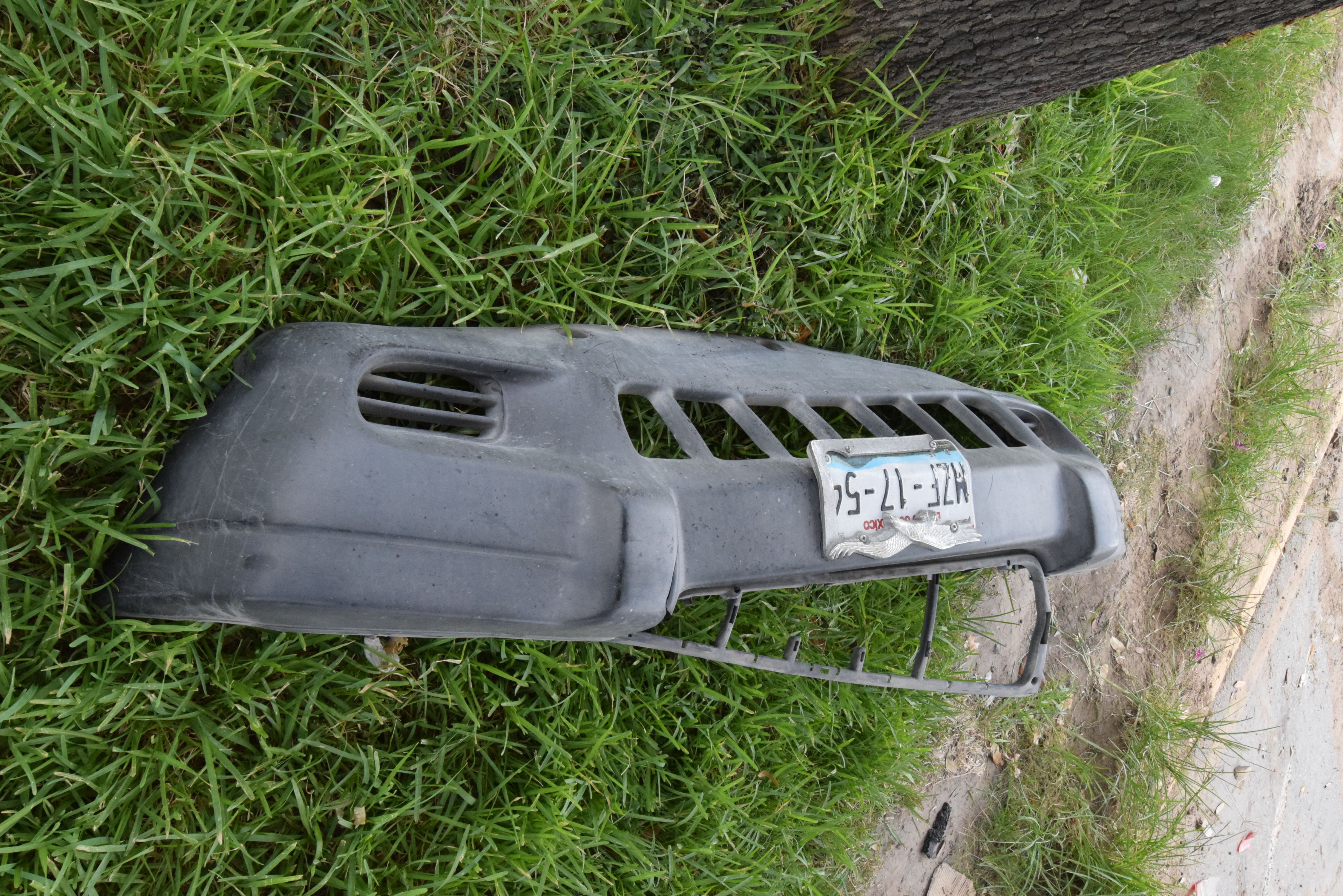EVIDENCIA. En el lugar del accidente quedó la defensa delantera con una placas de circulación de la camioneta Jeep que ocasionó el accidente y luego escapó.