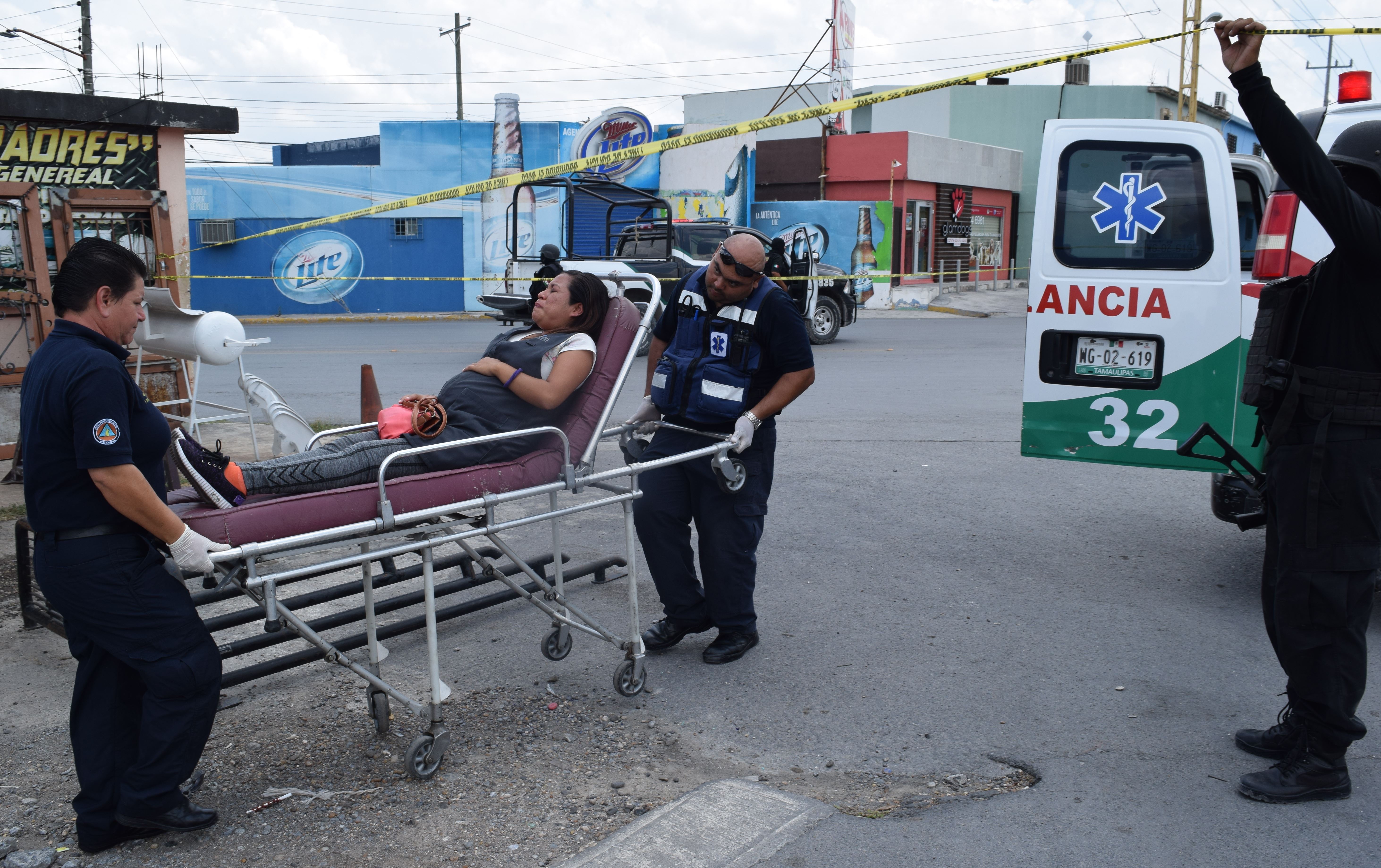 VÍCTIMA COLATERAL. La joven embarazada es trasladada al IMSS por paramédicos de Protección Civil, al resultar lesionada durante una de las persecuciones y balaceras registradas ayer.