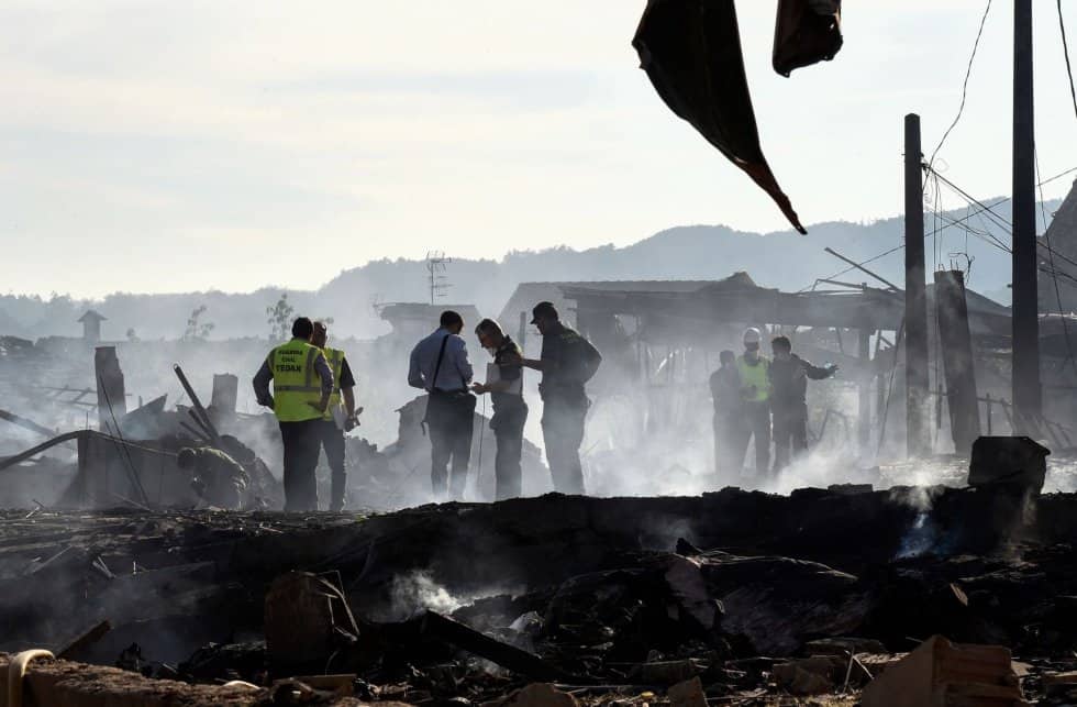 La onda expansiva ha causado numerosos daños en inmuebles y vehículos del entorno. En la imagen, un grupo de bomberos trabajan en la zona afectada. MIGUEL RIOPA AFP