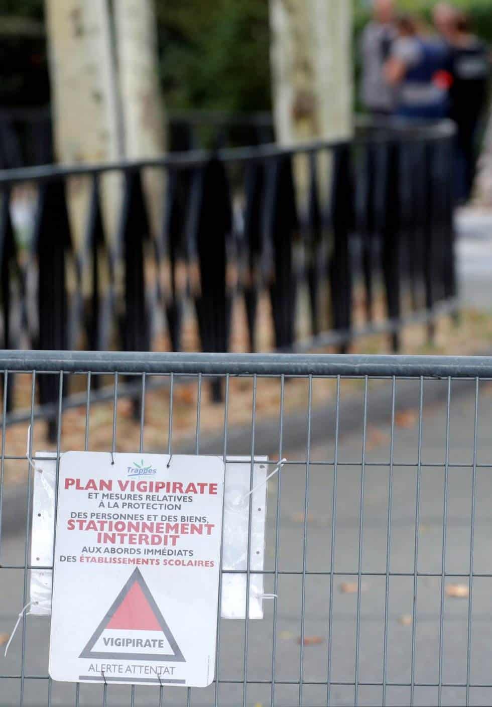 Se ve una señal de seguridad de Vigipirate mientras la policía francesa asegura una calle después de que un hombre matara a dos personas e hiriese a otra en un ataque con cuchillo en Trappes, cerca de París.