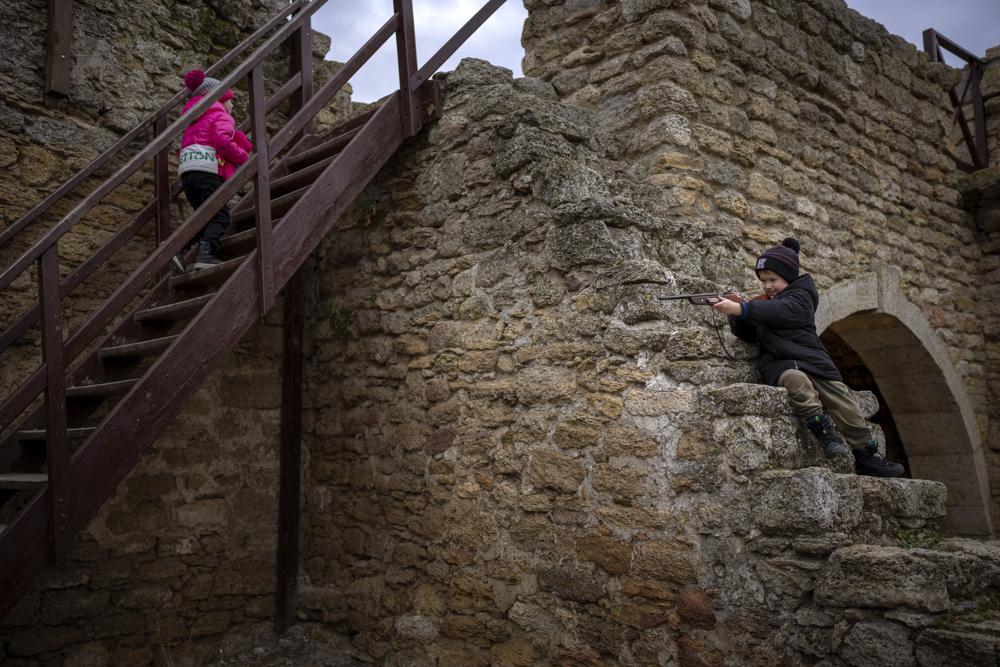 Mark, de 5 años, juega con su arma de juguete junto a su hermana mientras visitan la fortaleza Akkerman en el río Dnester, en la región de Odessa, Ucrania, el sábado 19 de febrero de 2022.