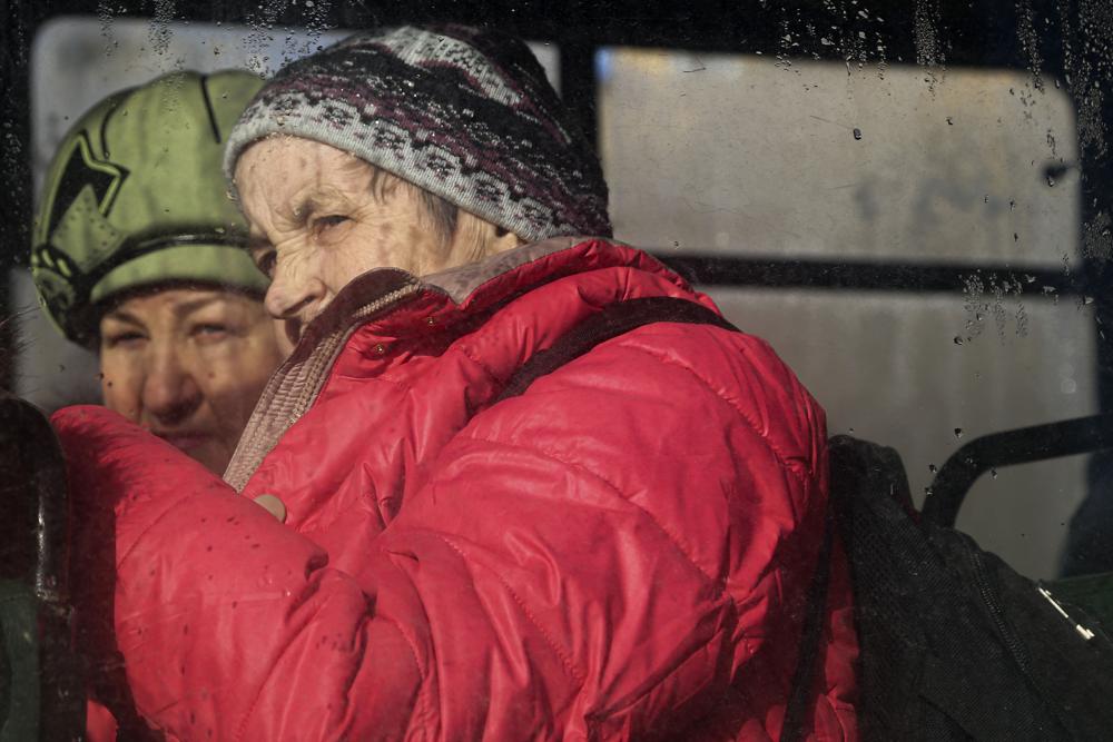 Se ve a dos mujeres a través de la ventana de un autobús, esperando ser evacuadas a Rusia, en Donetsk, el territorio controlado por militantes prorrusos, en el este de Ucrania, el sábado 19 de febrero de 2022.