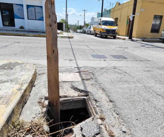 ‘Cubren’ con madera alcantarilla abierta
