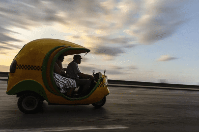 Residentes circulan en un coco taxi, normalmente utilizado por turistas, en La Habana, Cuba.