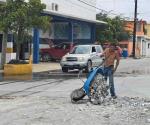 Tapan baches con escombro