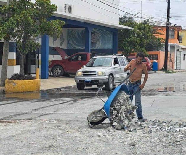 Tapan baches con escombro