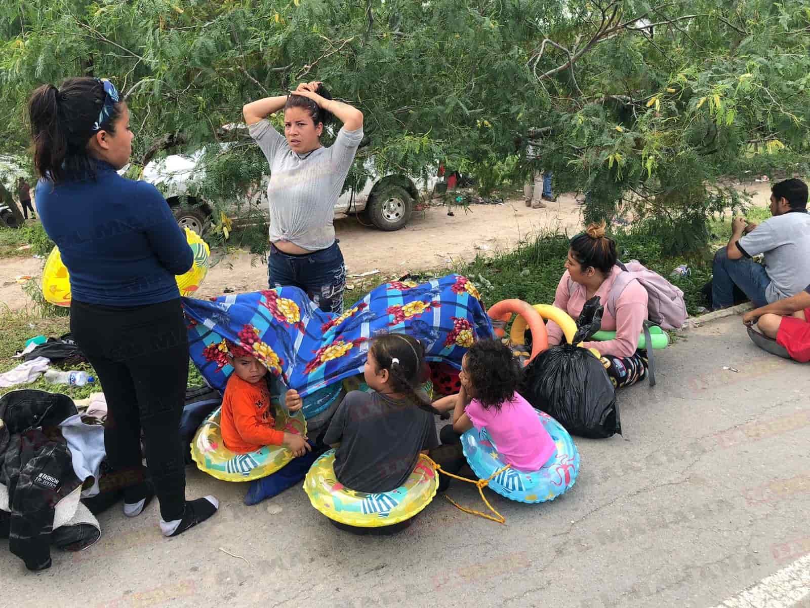 Padres e hijos en espera de una oportunidad de cruzarse el río de manera ilegal