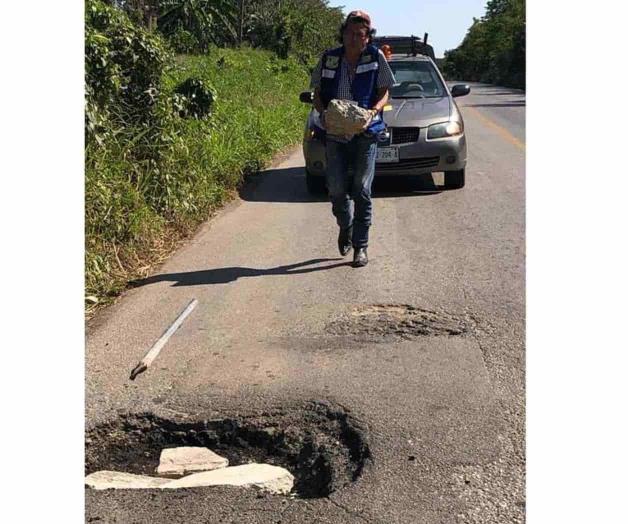 Reparan baches de forma artesanal en las carreteras