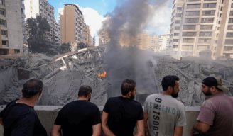 Varias personas contemplan los daños causados en un edificio tras un bombardeo israelí sobre Beirut, este miércoles.