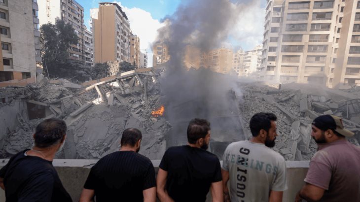 Varias personas contemplan los daños causados en un edificio tras un bombardeo israelí sobre Beirut, este miércoles.