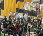 Protestan migrantes contra deportaciones en muro de Tijuana