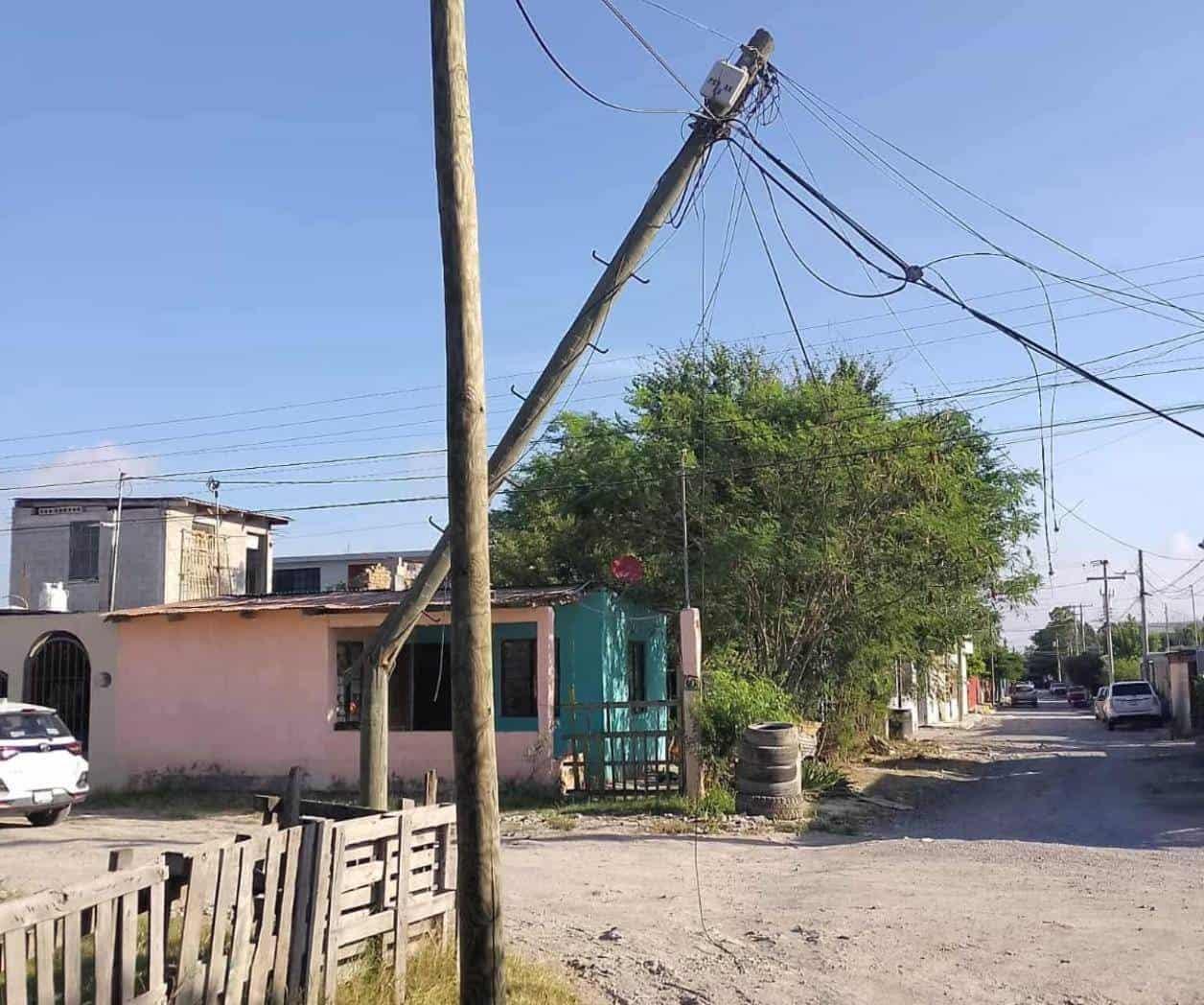 Queda colgando poste tras choque