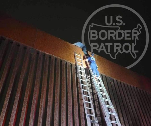 Rescatan migrante trepado en el muro Rescatan migrante trepado en el muro